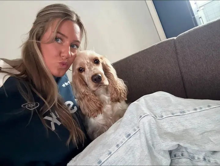 Nowi zit op de bank met Belle, een blonde cockerspaniël, tegen haar aan